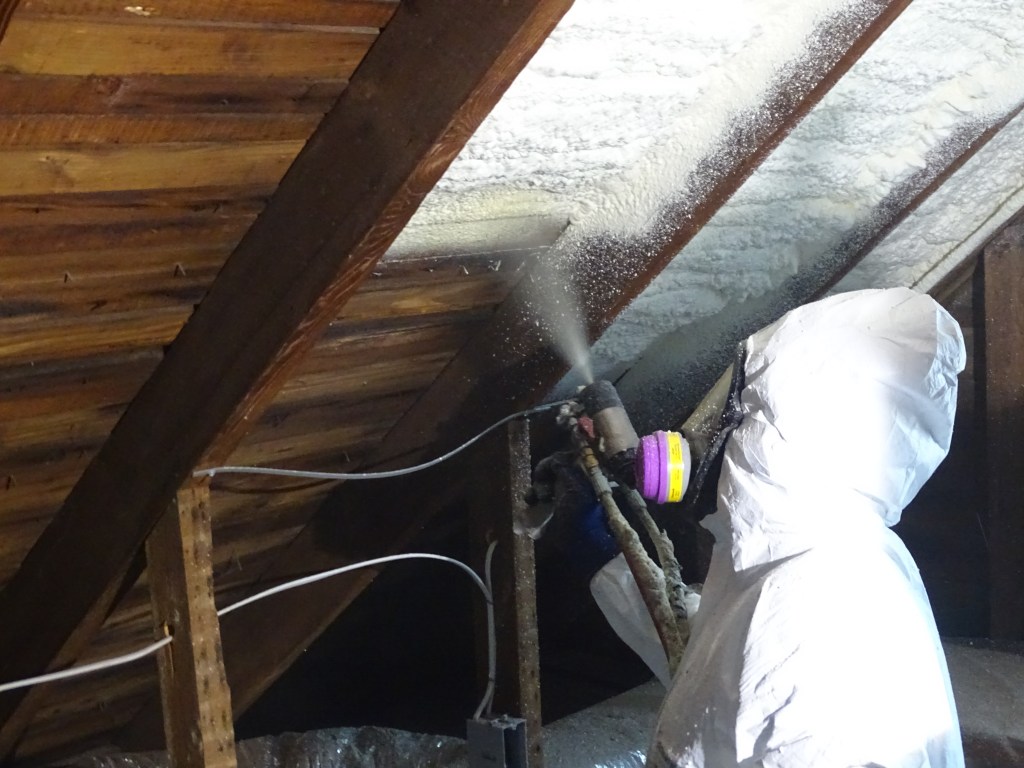 Gemini Spray Foam Systems worker applying spray foam to angled ceiling