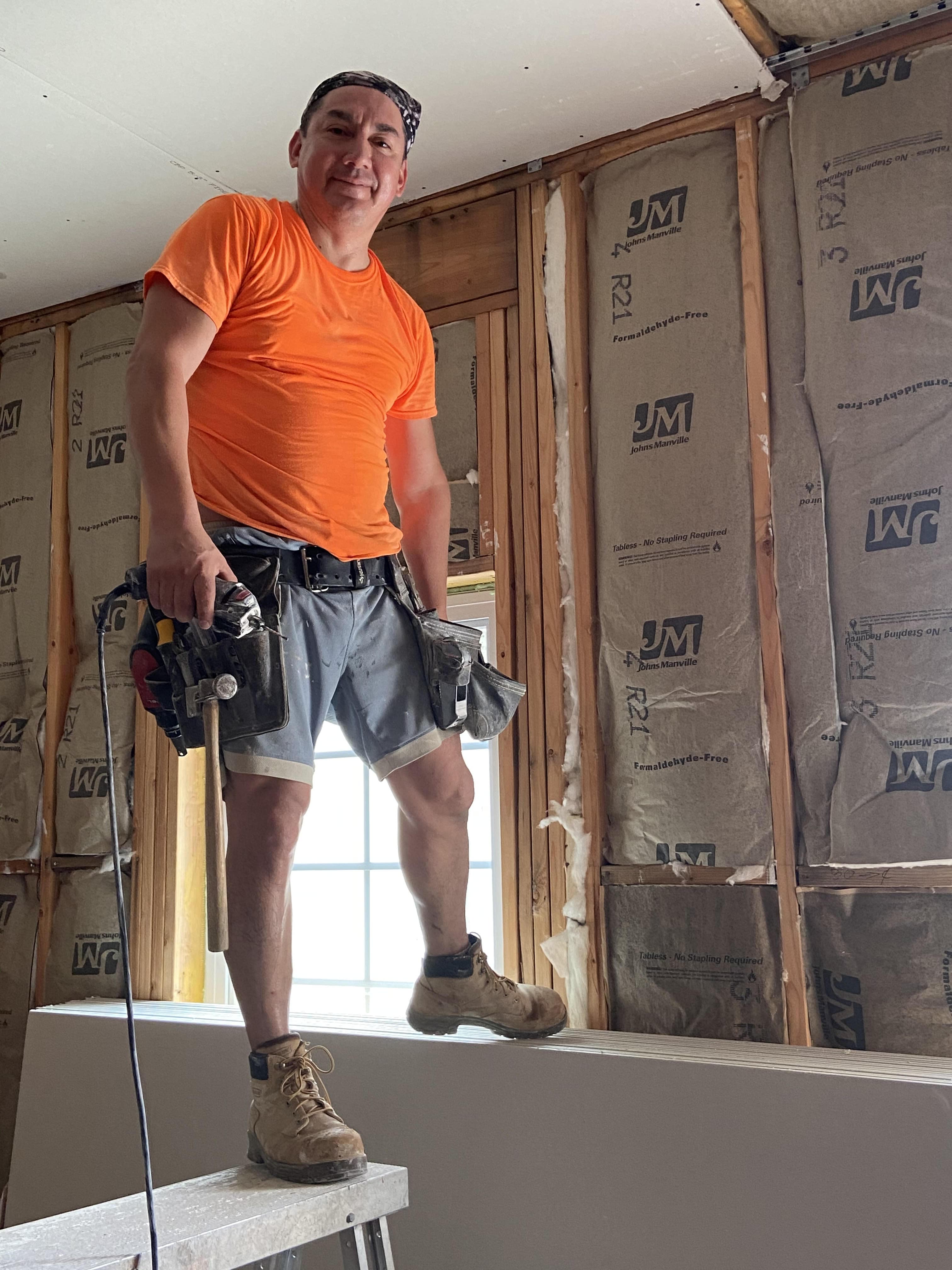 worker with various tools standing near paperbacked Johns Manville paperbacked insulation
