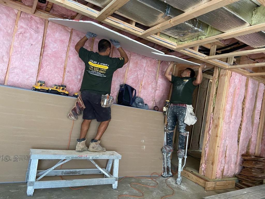 two workers installing sheet rock in rumson, nj