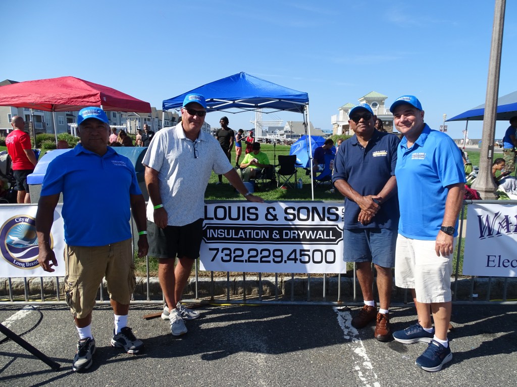Roberto, Bob, Gus, and Mike in front of Louis & Sons sign at the boxing event