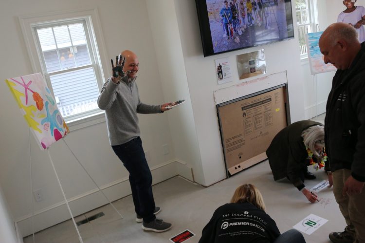 Matthew Amato of CMM Homes with paint on hand about to stamp the floor