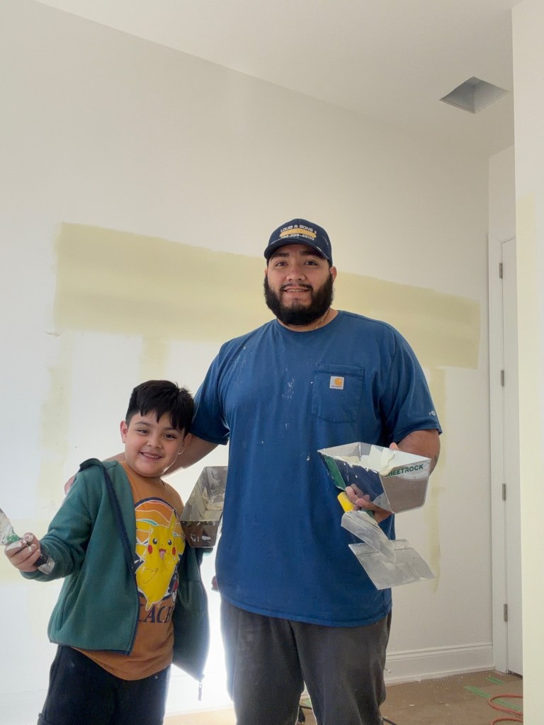 Javier and his son with spackle trowels