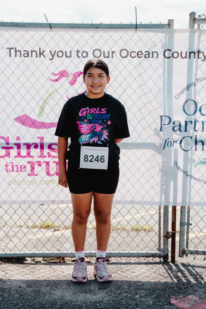 Norman's daughter standing near Girls on the Run banner